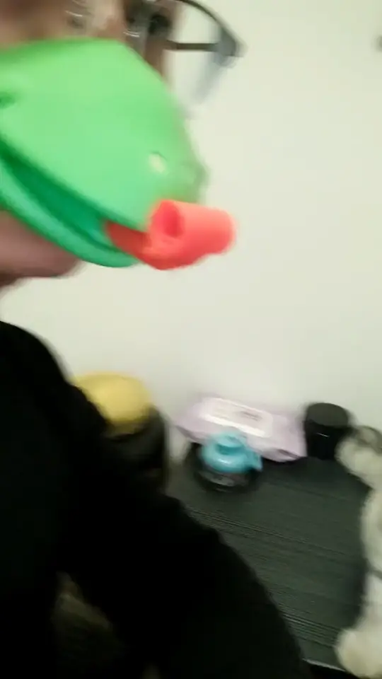Black cat reacting to a small green toy in a funny pet prank moment